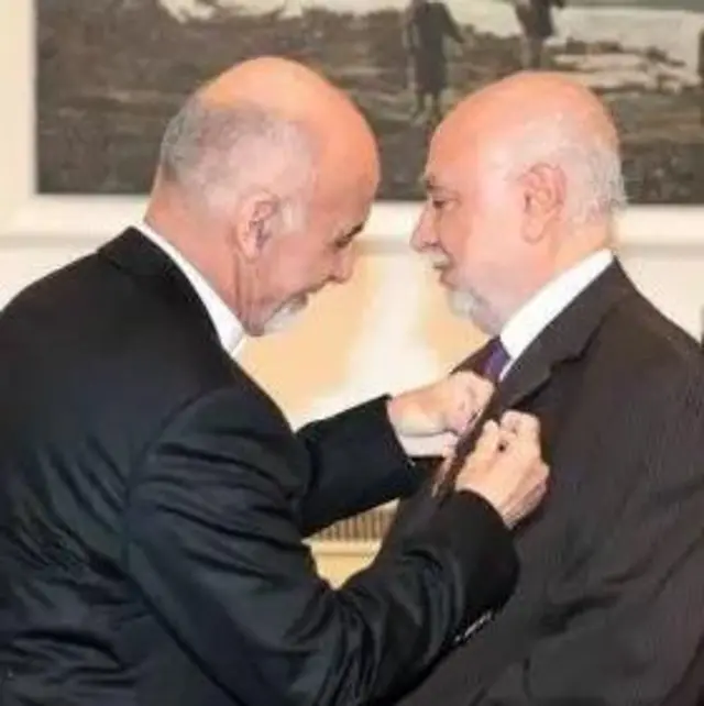 اشرف غنی، رئیس جمهور دولت پیشین افغانستان در حال نصب مدال دولتی بر شانه عبدالسلام عظیمی.