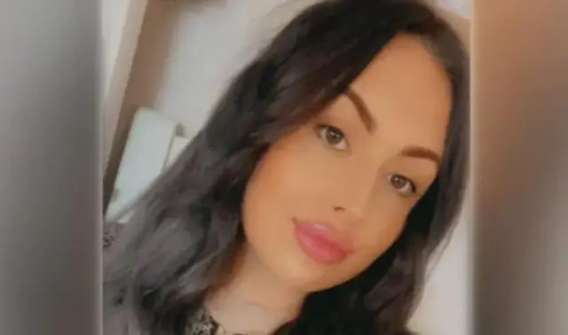 Джейд, жінка з довгим каштановим волоссям, посміхається в камеру. Це її селфі з головою та плечима.