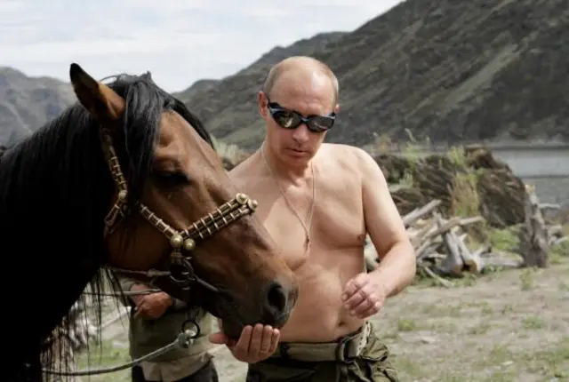 Putin üstsüz güneş gözlüklü atı eliyle besliyor, 3 Ağustos 2009.