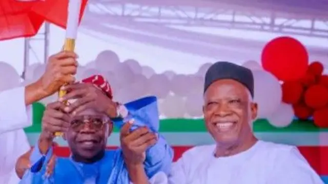 Aarẹ Bola Tinubu wọ asọ agbada toke tilẹ alawọ buluu ati filaalawọ waini, igbakeji rẹ, Kashim Shettima to wọ agbada funfun, fila dudu, duro tii lẹgbẹ, awọn mejeeji gbe asia ẹgbẹ oselu APC soke