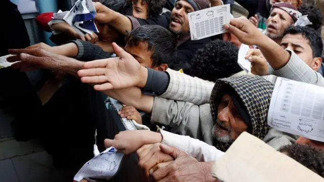 সরকারি কাগজপত্র হাতে নিয়ে কয়েকজন লোক  কিছু চাইছেন