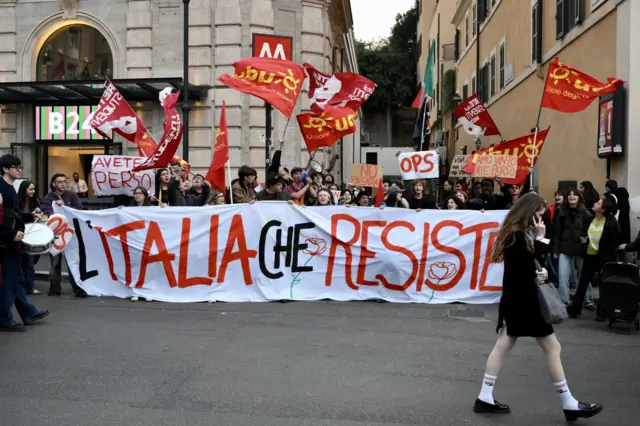 İtalya’nın başkenti Roma’da, yargı sistemi reformuna ilişkin anayasal referandumda “Hayır” oyunun kazanmasını kutlayan insanlar, üzerinde “İtalya güçlü duruyor” yazılı pankartla birlikte bayraklar ve dövizler taşıyor, 23 Mart 2026.