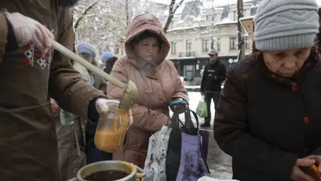 В одному з районів Києва люди стоять у черзі за гарячим обідом