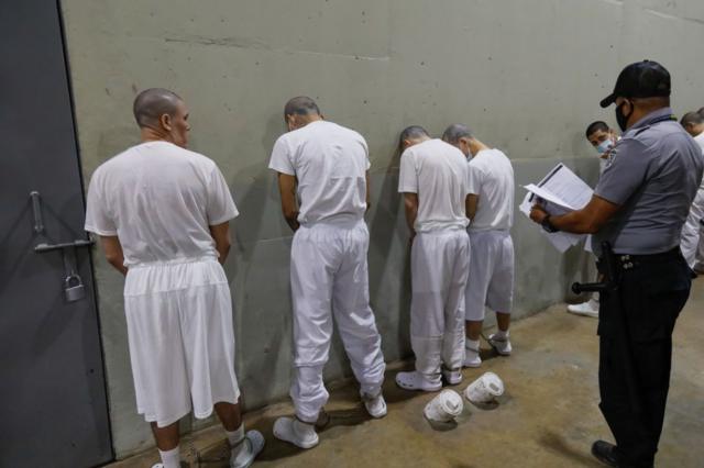 Guardas observam prisioneiros em uma prisão em El Salvador