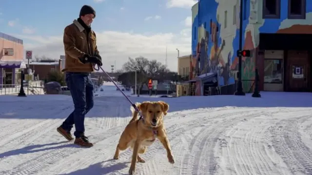 Un hombre camina con su perro en una calle del estado de Texas