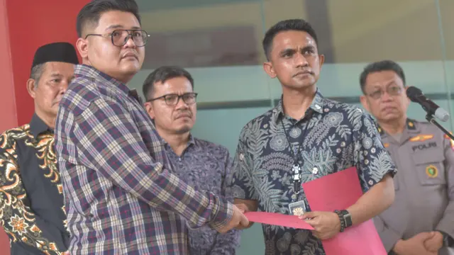 Kanit IV Subdit Resmob Ditreskrimum Polda Metro Jaya, AKP Charles Bagaisar (kedua kanan) memberikan berkas kepada Dany Aji keluarga Alm Reno (kedua kiri) di Rumah Sakit Polri, Jakarta Timur, Jumat (7/11/2025).