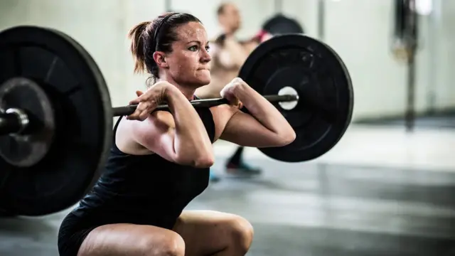  Woman exercising with weights in gym