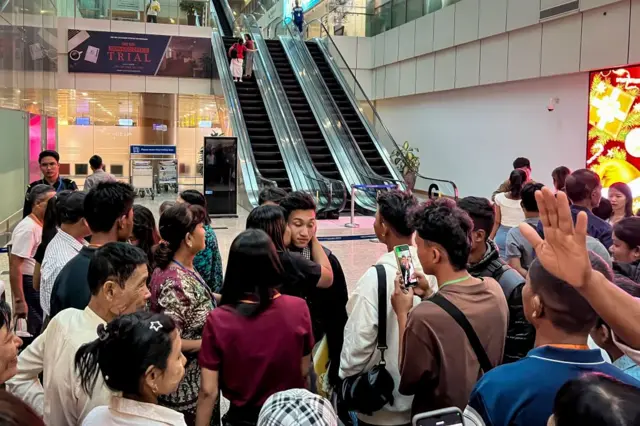 လေဆိပ်ထဲက ပြည်ပစက်လှေကားအနီးမှာ ရပ်နေတဲ့ လူအုပ်စု