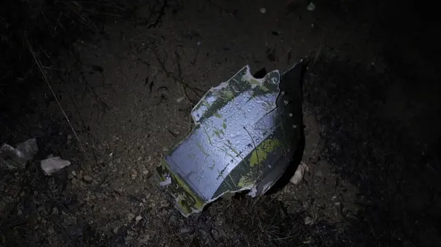 Düşen uçağın kalıntılarından bir parça karanlıkta 