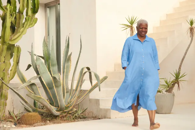 Mulher negra andandocasino bonus no cadastroum pátio, descança, com vestido azul