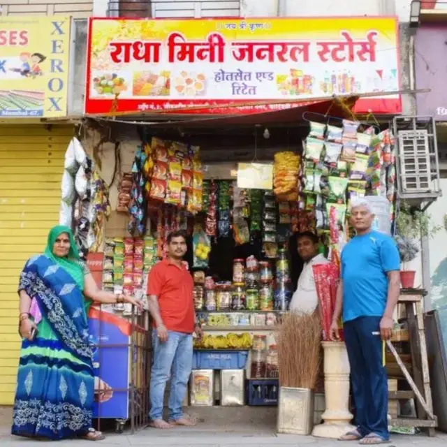 Radha Yadav's family, including her father Omprakash (first from right), outside the store she opened with her earnings