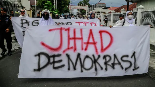 Massa yang tergabung dalam Aliansi Masyarakat Maluku Utara membentangkan spanduk saat berunjuk rasa di depan Kantor KPU Provinsi Maluku Utara, Ternate, Senin (2/12/2024). Mereka mendesak KPU Provinsi Maluku Utara dan Bawaslu untuk mendiskualifikasi salah satu pasangan calon Gubernur dan Wakil Gubernur Maluku Utara nomor urut 4 Sherly Tjoanda dan Sarbin Sehe karena diduga melakukan kecurangan dalam Pilkada Malut 2024 serta menghentikan proses pemungutan suara ulang di dua tempat di Halmahera Utara dan Halmahera Tengah.