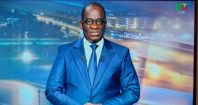 Alassane Séibou, ministre béninois de l'Intérieur en train de lire le communiqué du gouvernement à la télévision nationale.