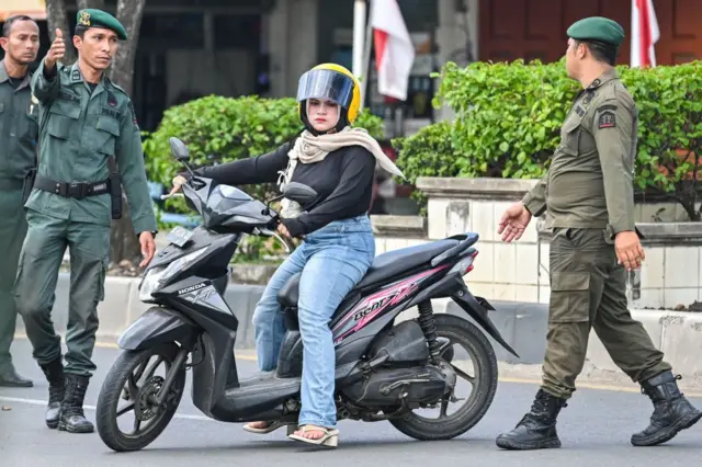 Polisi Syariah Aceh menghentikan perempuan yang dianggap melanggar aturan berpakaian.