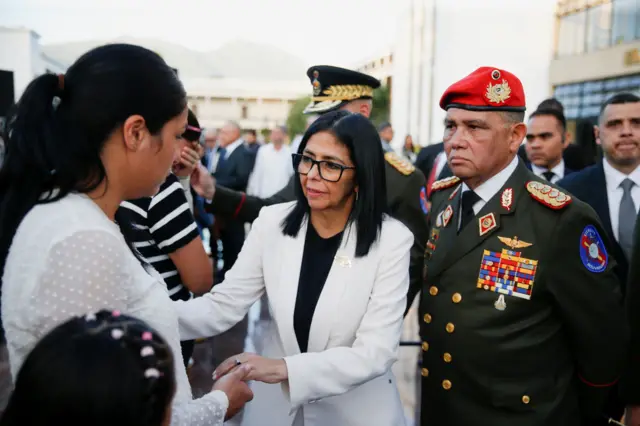 Delcy Rodríguez, en el centro, saluda a la esposa y la hija del capitán Moisés Sequera, a la izquierda junto al general Gustavo González López, a la derecha, vestido de militar, con boina roja y el pecho lleno de galones militares. 