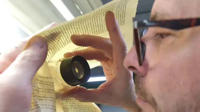 Seorang karyawan memeriksa kerta di perusahaan percetakan Normandie Roto Impression di Lonrai, Prancis. 