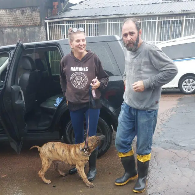 Casal com galochas pertobet365 north staffordshire reino unidocarro; a mulher segura um cachorro na coleira