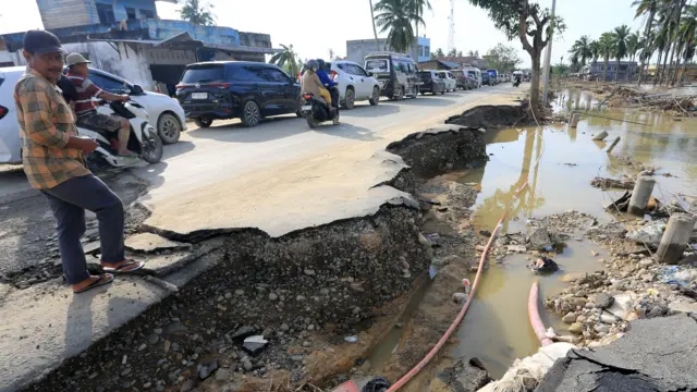 Sejumlah kendaraan antre melintasi Jalan Lintas Nasional Medan-Banda Aceh yang rusak akibat banjir di Desa Tualang Baro, Kecamatan Manyak Payed, Aceh Tamiang, Aceh, Kamis (4/12/2025).