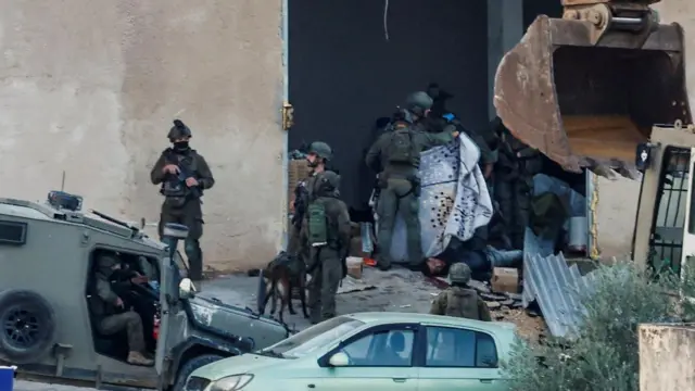 Soldados israelíes cubren con una manta los cuerpos de los palestinos tiroteados durante una redada en Yenín, en la parte de Cisjordania ocupada por Israel.