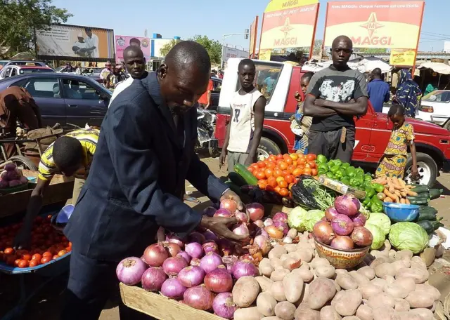 Des personnes examinent des produits sur un marché de Niamey.