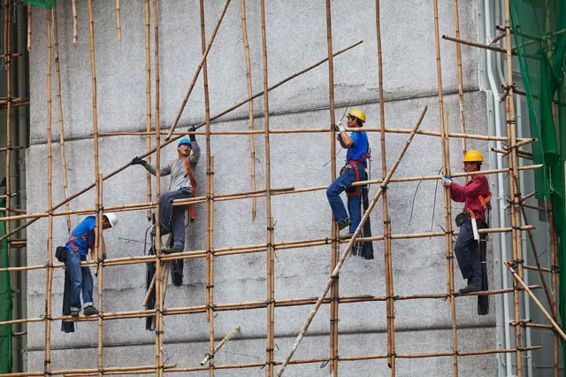 Operários em andaimes de bambu
