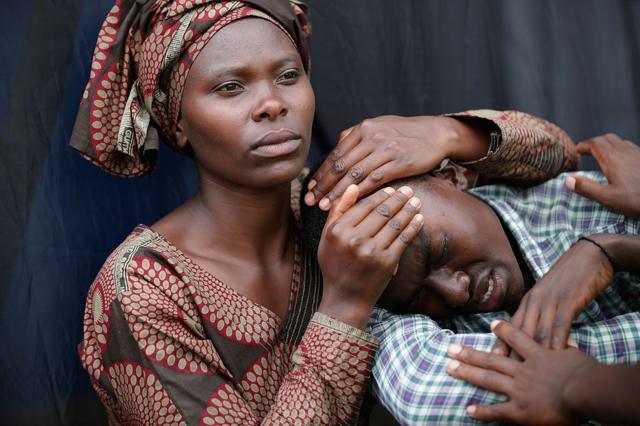 امرأة تواسي بيزيمانا إيمانويل، 22 عاما، خلال الذكرى العشرين للإبادة الجماعية عام 1994 في ملعب أماهورو في 7 أبريل 2014 في كيغالي، رواندا.