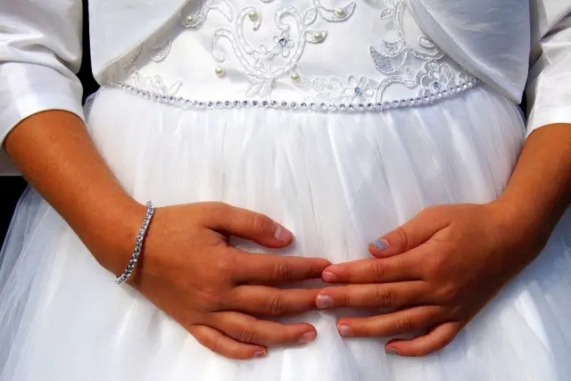 foto dekat tangan seorang perempuan dengan baju pengantin
