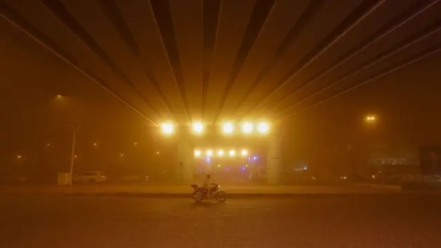 Muškarac vozi motor kroz oluju