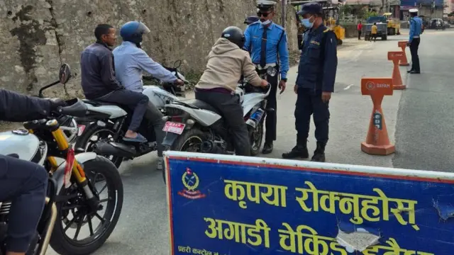 मोटरसाइकल चालकको जाँच गर्दै ट्राफिक प्रहरी