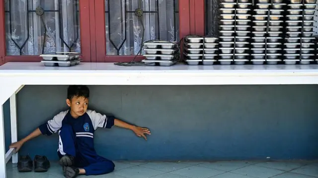 Seorang siswa menunggu makanan yang disediakan oleh program makan gratis di sekolah dasar di Banda Aceh pada 30 Oktober 2025.