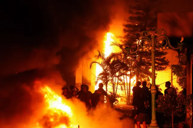 Pengunjuk rasa melihat gedung DPRD Sulawesi Selatan yang dilalap api saat aksi 29 Agustus di Makassar, Sulawesi Selatan, Sabtu (30/8/2025) dini hari. 