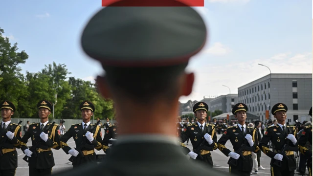 Chińscy żołnierze stoją w szeregu, na pierwszym planie żołnierz stojący tyłem