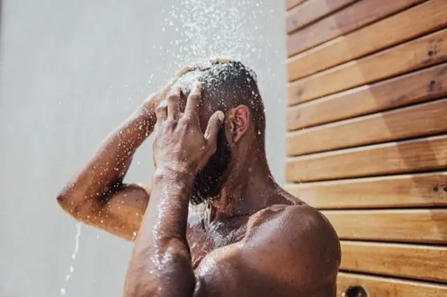 Homme prend une douche en plein air
