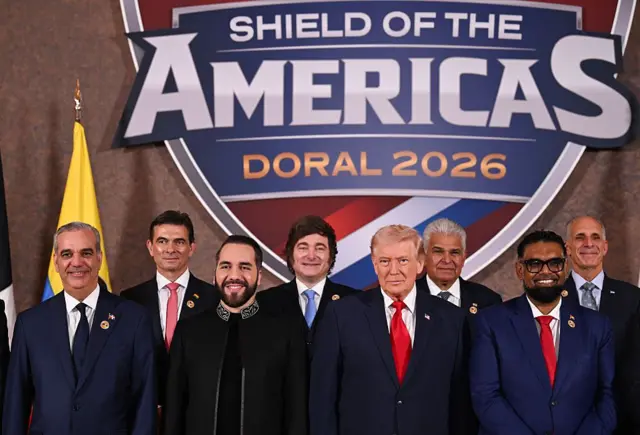 O presidente dos Estados Unidos, Donald Trump, está ao lado de (da esquerda para a direita) Luis Abinader, presidente da República Dominicana; Rodrigo Paz Pereira, presidente da Bolívia; Nayib Bukele, presidente de El Salvador; Javier Milei, presidente da Argentina; José Raúl Mulino, presidente do Panamá; Mohamed Irfaan Ali, presidente da Guiana; e Nasry “Tito” Asfura, presidente de Honduras, durante uma foto em grupo no início da “Cúpula Escudo das Américas”