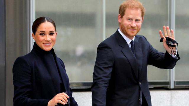 Meghan e Harry sorrindo para foto enquanto caminham com trajes formaisfutebol hoje brasileirãoárea externa