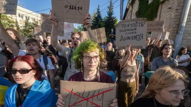 Учасники акції протесту проти обмеження повноважень НАБУ і САП тримають гасла на картонках