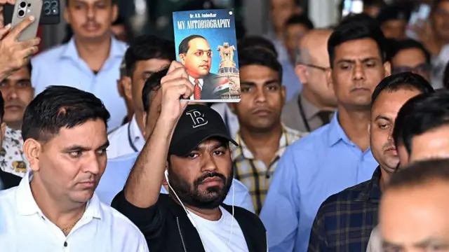 भारत आने के बाद हाथ में डॉ. बाबासाहेब आंबेडकर की तस्वीर वाली किताब लिए अभिजीत जंतर-मंतर की ओर रवाना हुए