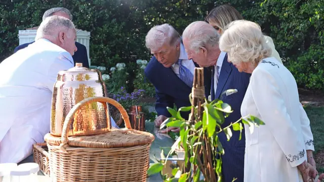 US President Donald Trump and First Lady Melania Trump with King Charles III and Queen Camila at the White House garden being shown jars of honey