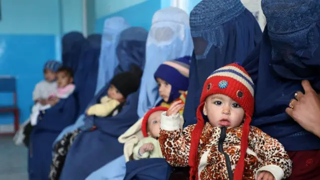 A group of women with babies waiting to see a doctor 