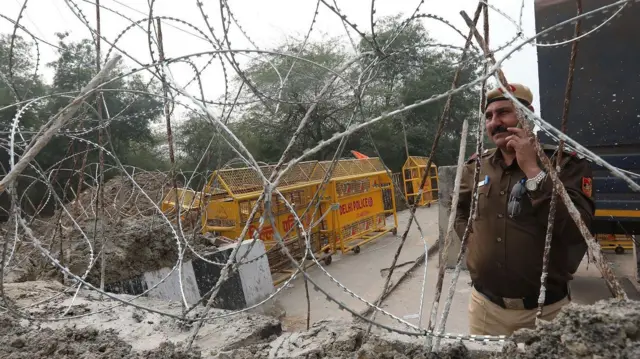 شرطي هندي بجانب حواجز