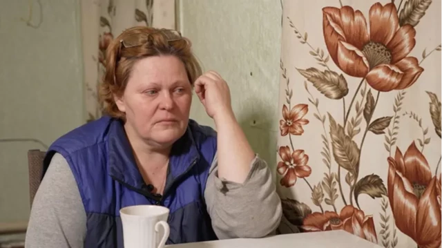 Olga assise à une table de cuisine