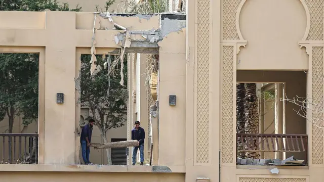 Рабочие убирают обломки, оставшиеся после удара иранских ракет по отелю Fairmont в Дубае 2 марта 2026 года.