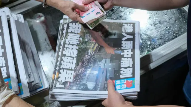 Una mujer compra 10 ejemplares del último número del periódico Apple Daily de Hong Kong