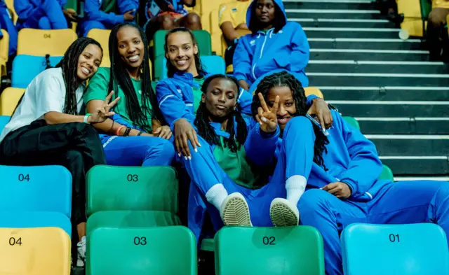 Mu gihe Uganda yariho ikina na DRC, abakinnyi b'u Rwanda bari baruhutse bari kuri stade bareba uyu mukino, imbere uhereye ibumoso hari Sifa Joiyeuse na Hope Butera