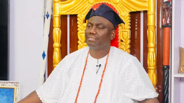 Alaafin Abimbola Akeem Owoade joko lori itẹ, wọn de fila abetiaja, wọn wọ asọ funfun, fi ilẹkẹ pupa sọrun