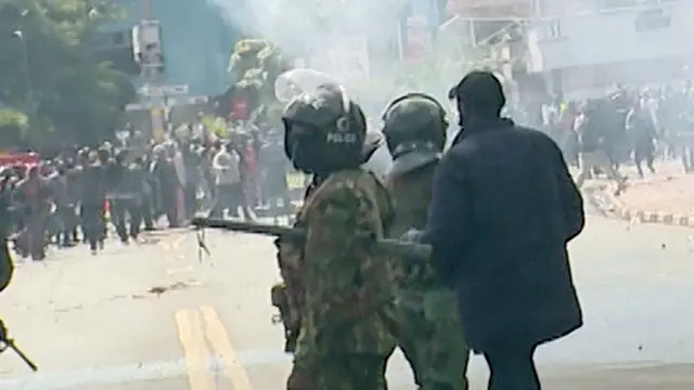 Le policier identifié par la BBC comme la personne qui a tué David Chege et Ericsson Mutisya - vu avec d'autres membres du personnel de sécurité et des manifestants dans une rue à l'extérieur du parlement.