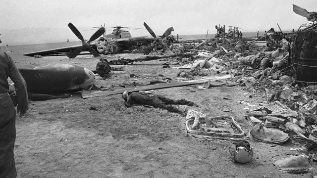 لاشه هلیکوپترهای آمریکایی در دشت کویر ایران. در پی این برخورد جیمی کارتر ماموریت مخفی نجات گروگان‌های آمریکای در ایران را نیمه کاره لغو کرد.