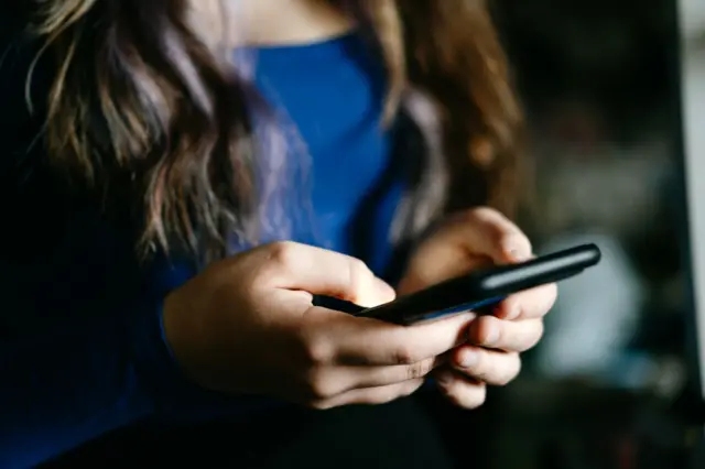 Una mujer sostiene un celular