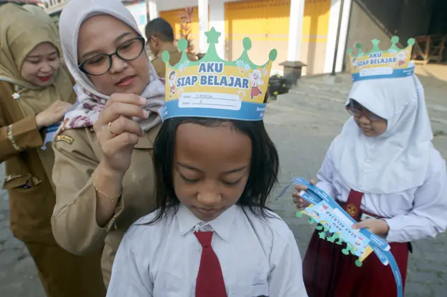 Guru memasangkan atribut kepala kepada siswa saat Masa Pengenalan Lingkungan Sekolah (MPLS) pada hari pertama tahun ajaran 2026/2027 di SDN 2 Plandaan, Tulungagung, Jawa Timur, Senin (13/7/2026). Sebanyak 16 siswa mengikuti MPLS yang berlangsung pada 13Ð18 Juli 2026 untuk membantu peserta didik beradaptasi dengan lingkungan sekolah serta menumbuhkan semangat belajar pada awal tahun ajaran baru.
