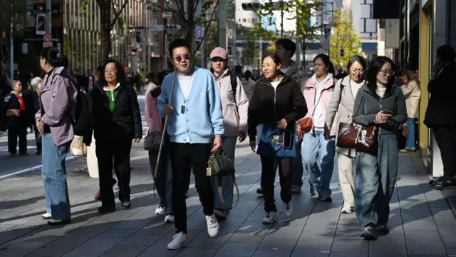 Turistas chinos caminan por una calle del distrito comercial de Ginza en Tokio el 22 de noviembre de 2025.
